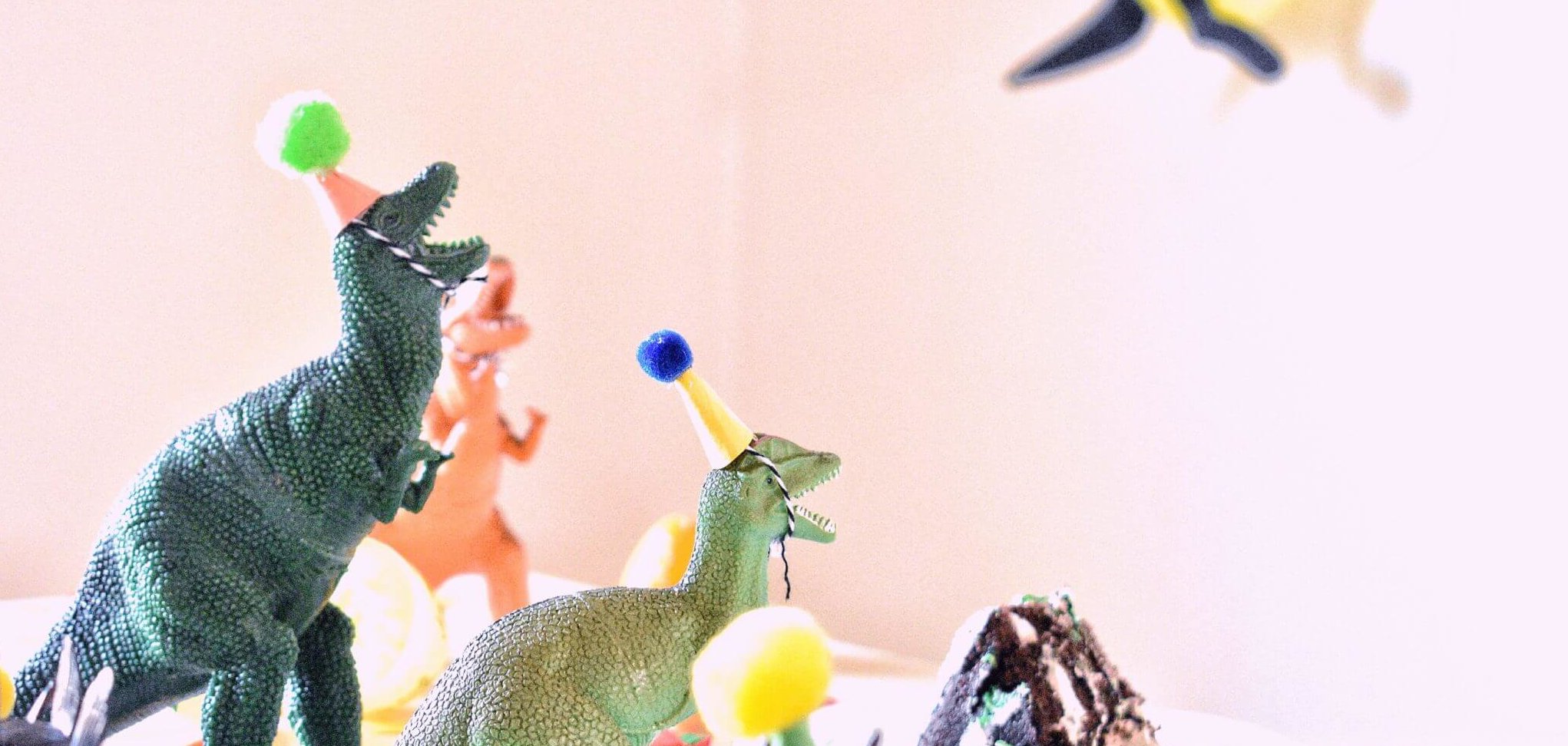 two dinosaurs stuffed toy in party hats