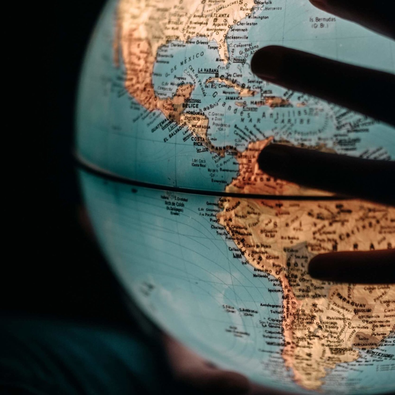Hands holding a backlit globe, meant to represent Mangrove’s global workforce.